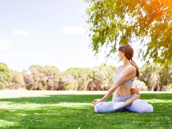 Genç kadın parkta yoga yapıyor. — Stok fotoğraf