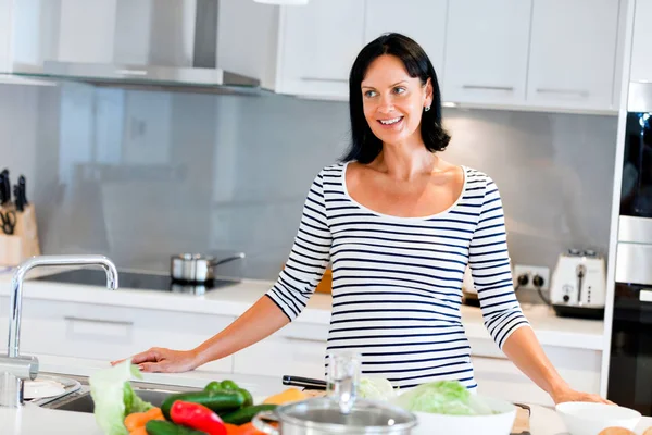 Mooie vrouw in de keuken staan en lachend — Stockfoto