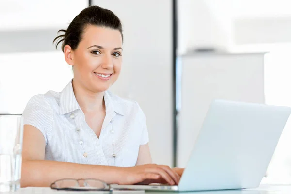 Porträt einer Geschäftsfrau, die im Büro am Computer arbeitet — Stockfoto