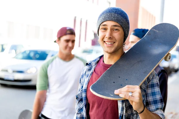 Dospívající chlapec kráčí na ulici s jeho skateboard — Stock fotografie