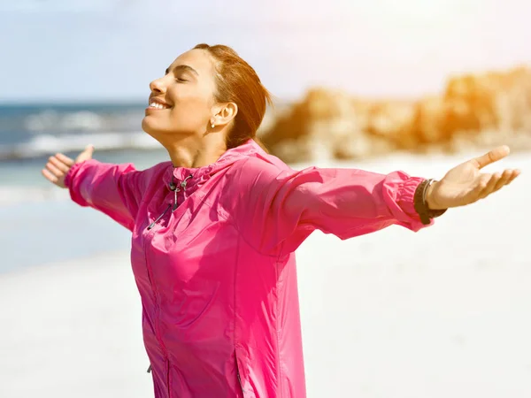 Jonge vrouw met sportkleding tegoed aan zee — Stockfoto