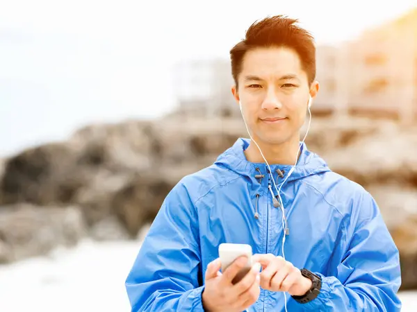 Спортивный человек с наушниками на берегу моря — стоковое фото