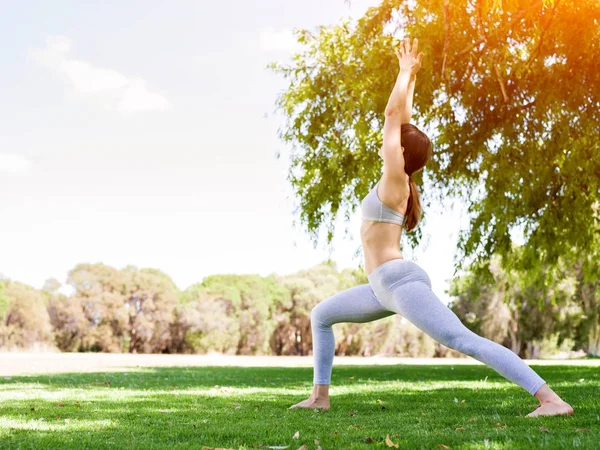 Genç kadın parkta yoga yapıyor. — Stok fotoğraf