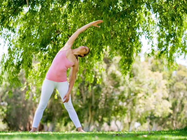 Giovane donna che fa yoga nel parco — Foto Stock