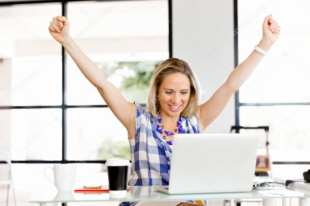 One young woman in office celebrating success