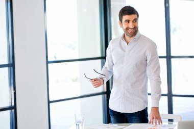 Ofiste duran genç beyaz iş adamı