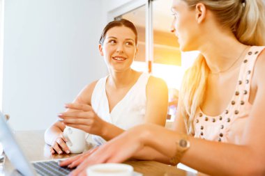 Birlikte laptop çalışan iki genç kadın