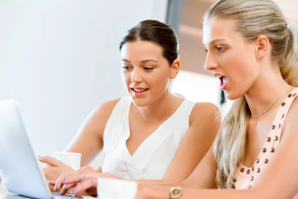 Två unga kvinnor arbetar tillsammans på laptop — Stockfoto