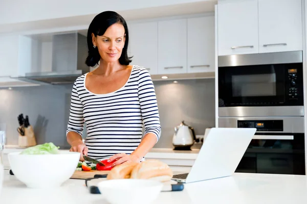 Mulher bonita de pé na cozinha e cozinhar — Fotografia de Stock