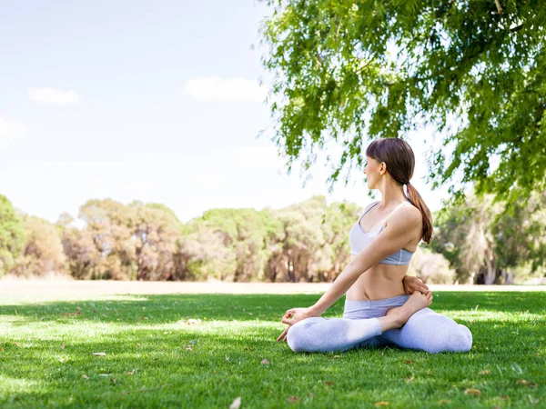 Молода жінка практикує йогу в парку — стокове фото