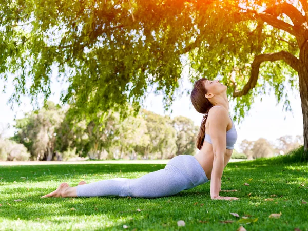 Genç kadın parkta yoga yapıyor. — Stok fotoğraf