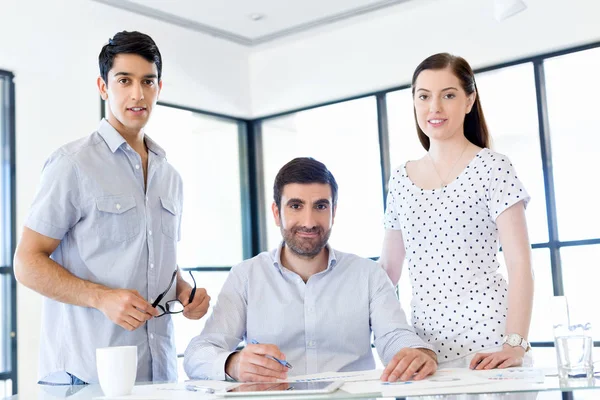 Groep van gelukkige jonge zakenmensen in een vergadering — Stockfoto