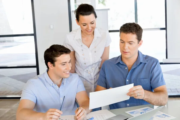 Groep van gelukkige jonge zakenmensen in een vergadering — Stockfoto