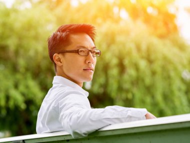 İş adamı parkta bir gazete okuyor