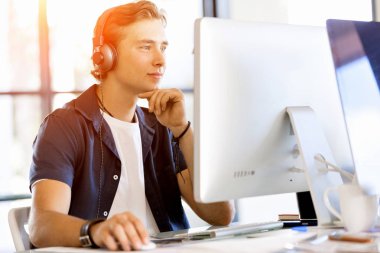 Kulaklıklar ile ofiste genç adam