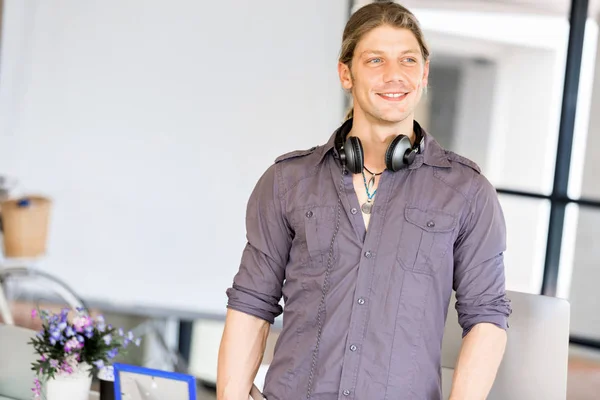 Young caucasian businessman standing in office — Stock Photo, Image