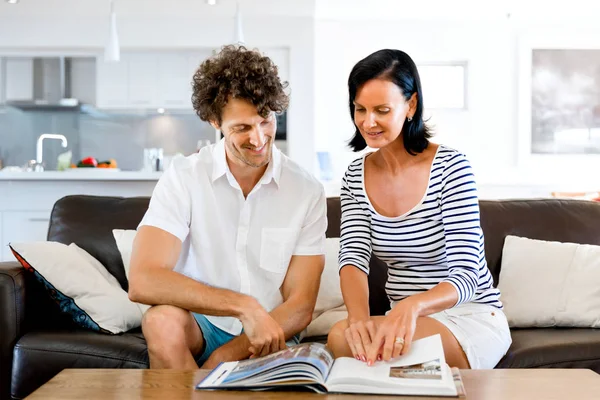 Pareja en casa con un libro — Foto de Stock