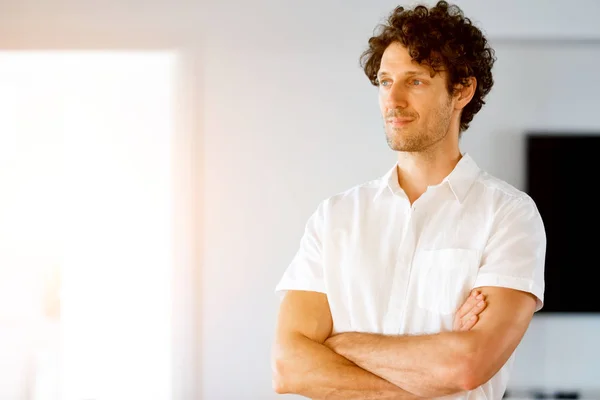 Portrait d'un jeune homme intelligent debout dans la cuisine — Photo