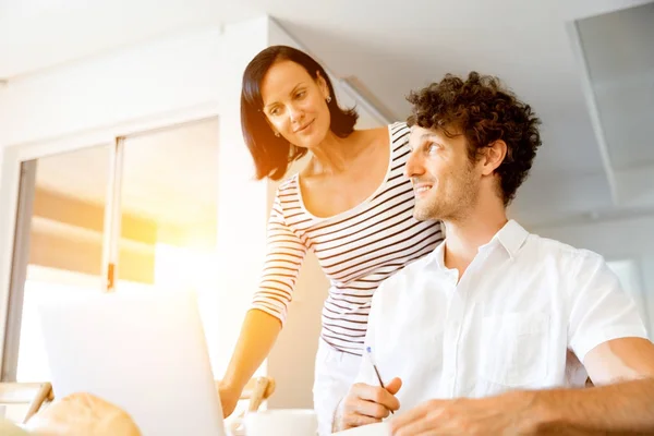 Feliz pareja moderna trabajando en el ordenador portátil en casa —  Fotos de Stock