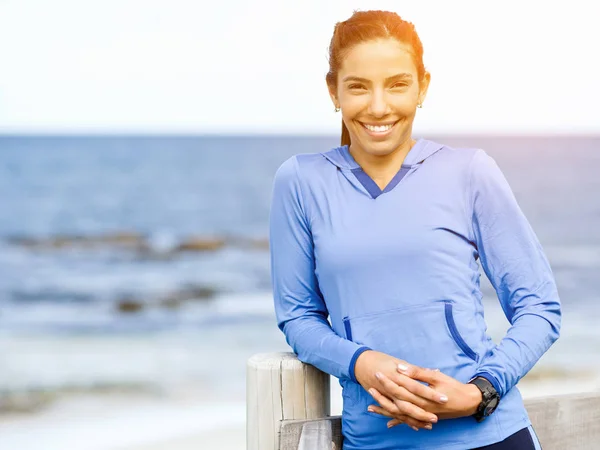 Sportieve vrouw in sportkleding staande aan de kust — Stockfoto
