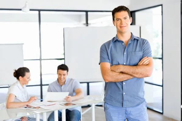 Young caucasian businessman standing in office — Stock Photo, Image