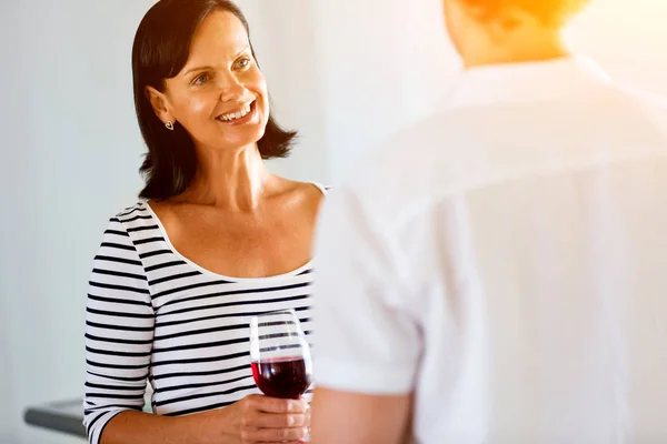 Femme avec un verre de vin parlant à un homme — Photo