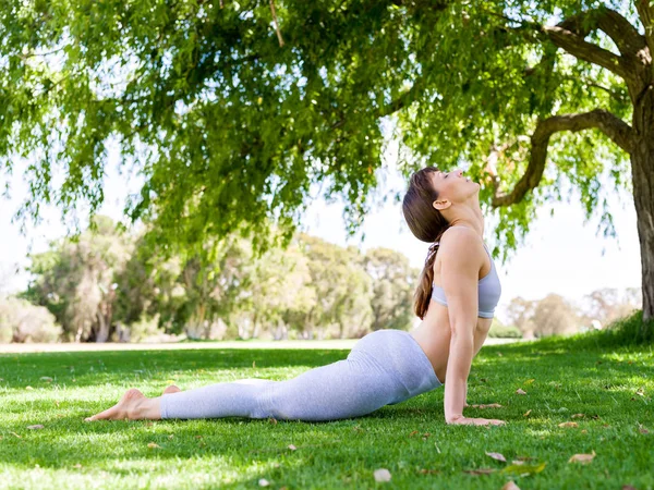 Jeune femme pratiquant le yoga dans le parc — Photo