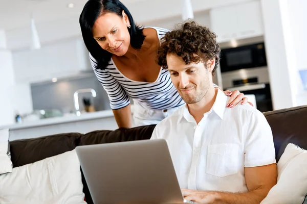 Pareja en casa usando laptop — Foto de Stock