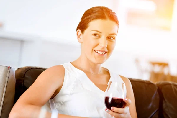 Hermosa mujer joven sosteniendo copa con vino tinto — Foto de Stock