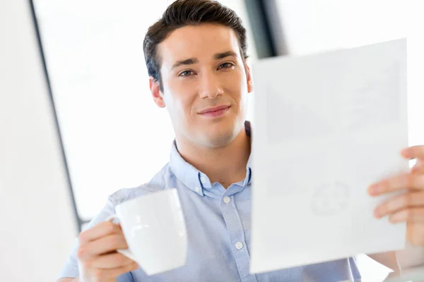 Jungunternehmer im Amt mit Becher — Stockfoto