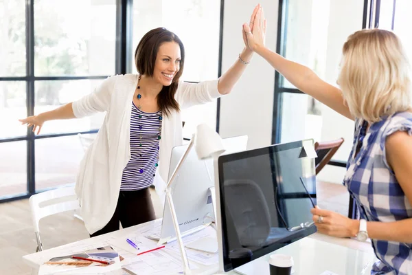 Zwei junge Frauen im Amt feiern Erfolge — Stockfoto