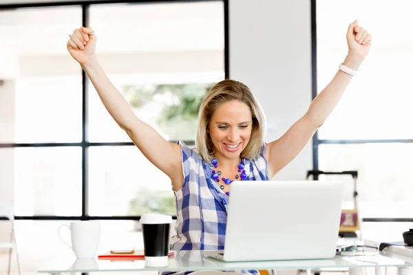 Uma jovem no escritório celebrando o sucesso — Fotografia de Stock