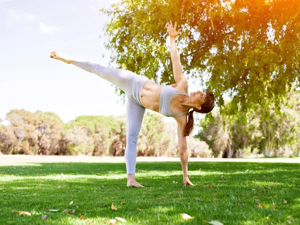 Mujer joven practicando yoga en el parque —  Fotos de Stock