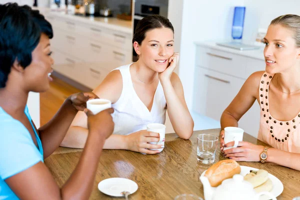 Счастливые друзья разговаривают и пьют кофе и чай — стоковое фото