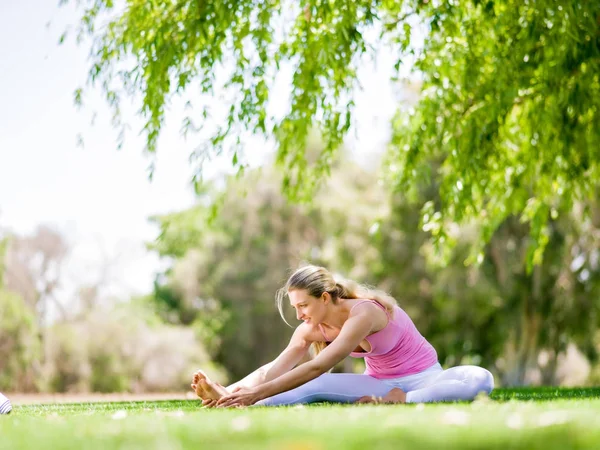 Parkta yoga yapan genç kadın. — Stok fotoğraf