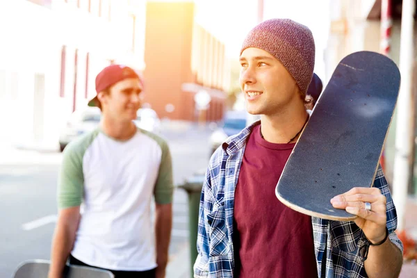 Друзья-подростки гуляют по улице на скейтбордах — стоковое фото