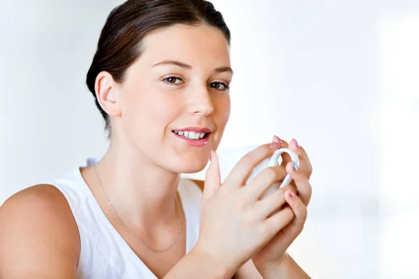 Giovane donna felice con una tazza di tè o caffè a casa — Foto Stock