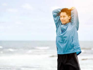 Genç adam sahilde egzersiz yaparak