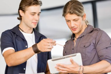 Genç yakışıklı işadamı onun touchpad ayakta kullanma office