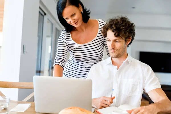 Gelukkige moderne paar bezig met laptop thuis — Stockfoto