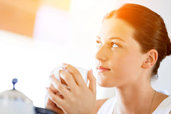 Mujer joven feliz con taza de té o café en casa — Foto de Stock
