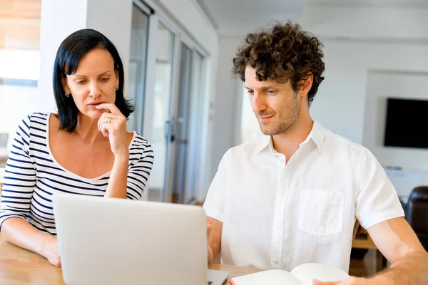 Gelukkige moderne paar bezig met laptop thuis — Stockfoto