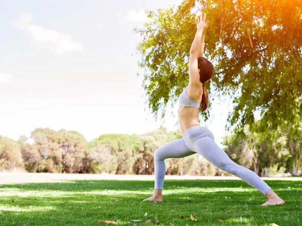 Genç kadın parkta yoga yapıyor. — Stok fotoğraf