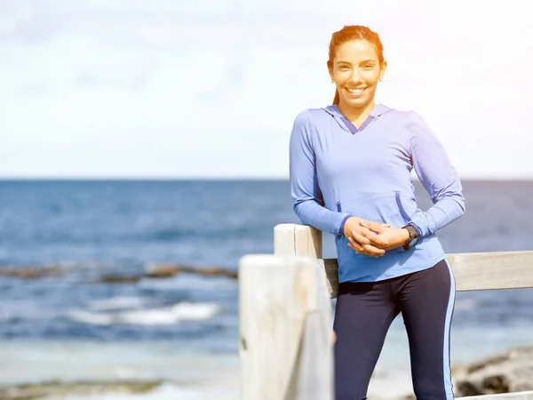 Donna atletica in abbigliamento sportivo in piedi al mare — Foto Stock