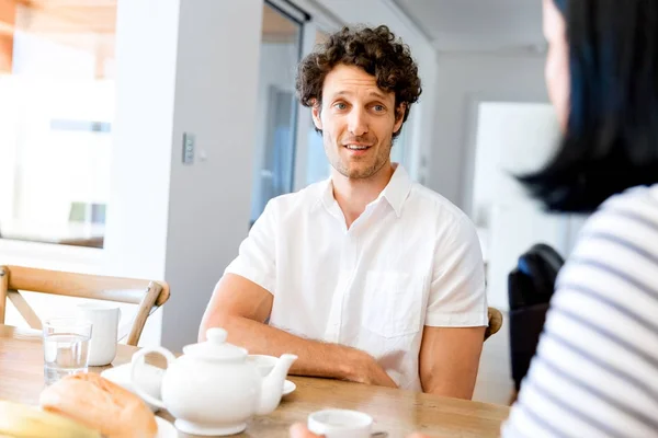 Portrait of man sitting and talking to woman indoors — Stock Photo, Image