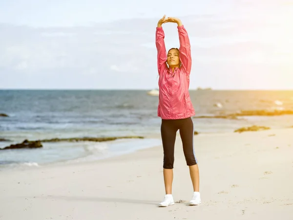 Mujer joven en la playa haciendo ejercicios — Foto de Stock