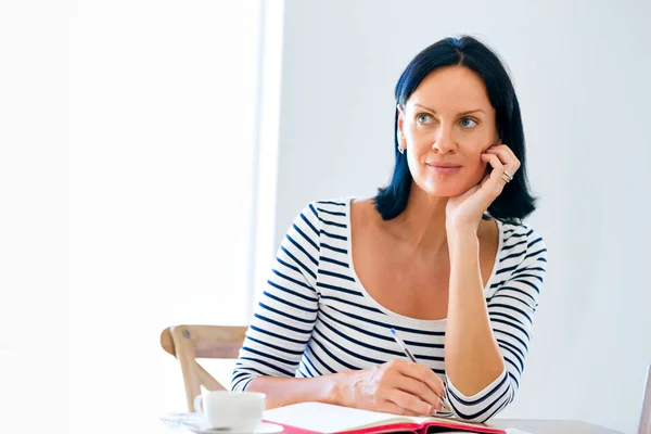 Pretty woman writing in an agenda at home or office — Stock Photo, Image