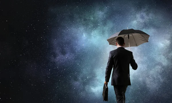 Бизнесмен с чемоданом и зонтиком — стоковое фото