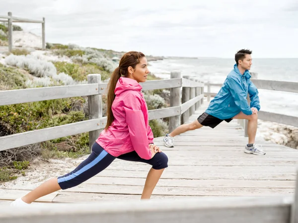 Jovem casal à beira-mar fazendo exercícios — Fotografia de Stock