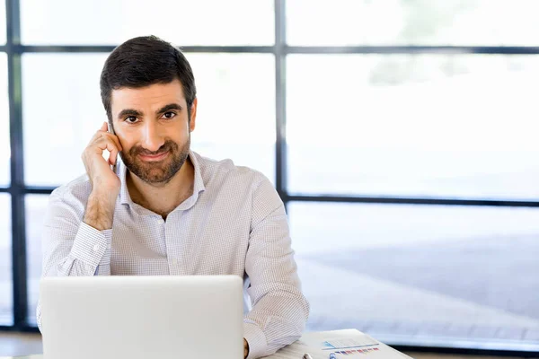 Sebevědomý mladý muž v smart casual oblečení drží telefon — Stock fotografie